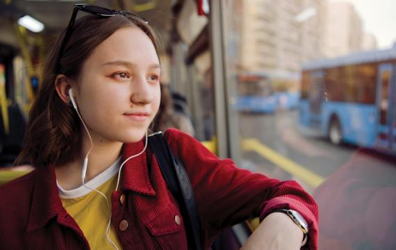Tween sitting on a bus looking out the window
