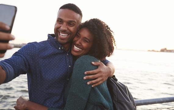 Happy couple smiling and taking a selfie on a kid-free vacation