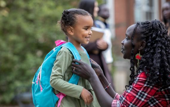 Mom saying goodbye to her daughter on the first day of kindergarten 