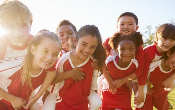 Group of kids on a sports team ready for a team snack when the game is over