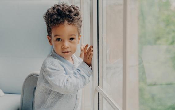 Young boy standing by a window
