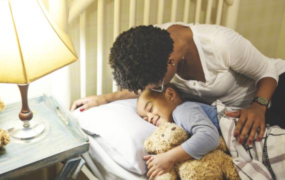 Mom putting her son to bed