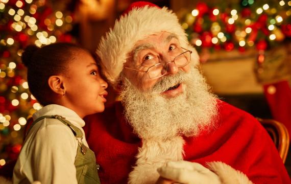 Santa photos Seattle best place to get Santa photos a little girl whispers into Santa's ear during a photo session