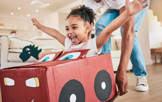 Girl in a cardboard box that is made into a car