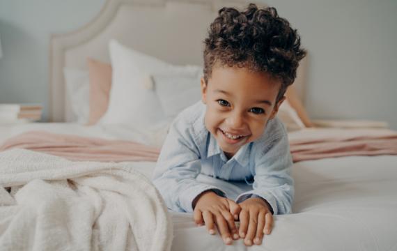 Child in a bed happy about getting better sleep