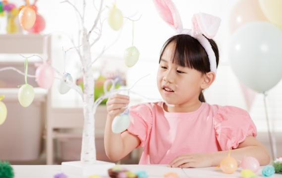 Young girl hanging up Easter decorations