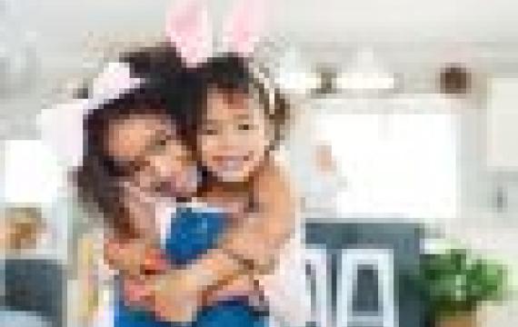 Cute sisters wearing bunny ears share a hug. Best Seattle Easter egg hunts for kids and families 2024