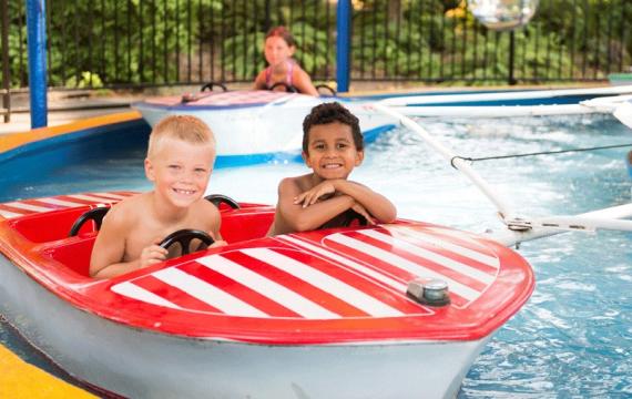 Two kids on a red and white striped boat at Water Waves Theme and Water Park in Federal Way near Seattle