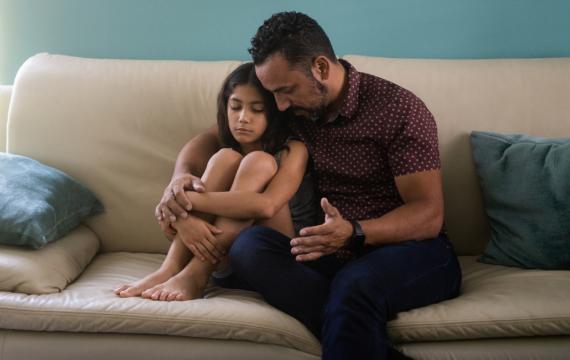 Dad and daughter talking on a couch