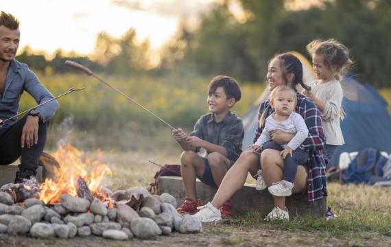 family camping with young children and sitting around a camp fire 