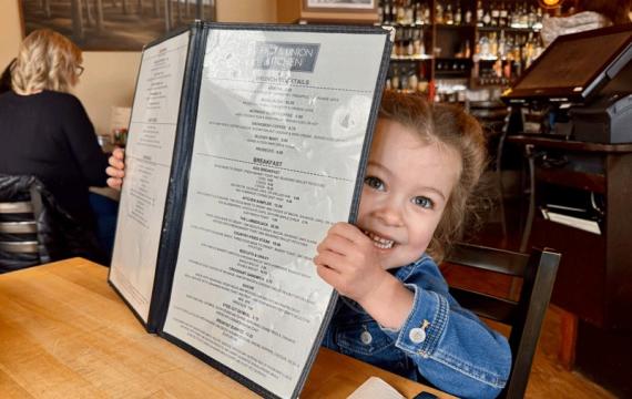 young girl reading menu at First and Union Kitchen in Snohomish, a brunch spot for Seattle-area families