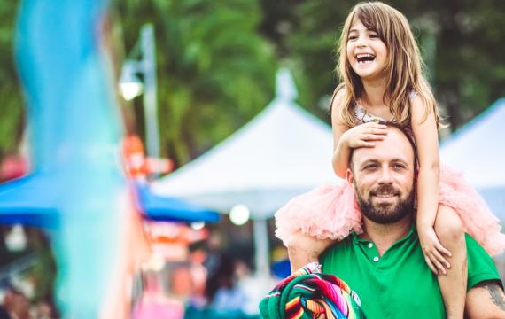 dad with daughter on shoulders at a spring family festival