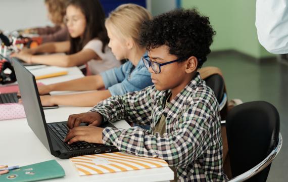 boy using a laptop in a classroom