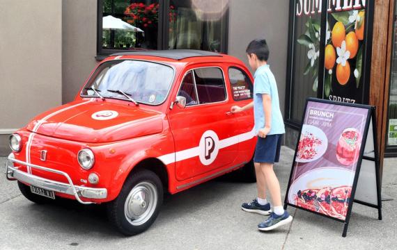 young boy walking up to vintage Fiat outside Piatti, a fun Seattle brunch spot