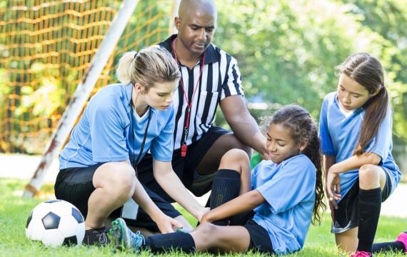 girl playing soccer who has hurt her ankle