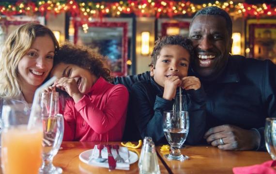 A family enjoys eating a meal out at a restaurant on Christmas Day.