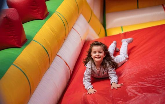 young girl sliding down inflatable slide during a seattle kids night out