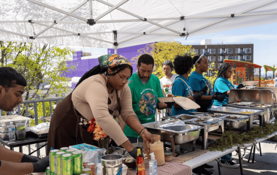 Community cooking event under a tent with food in Seattle
