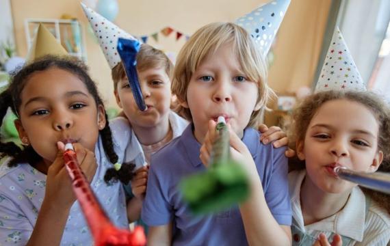 children holding party blowers and having fun