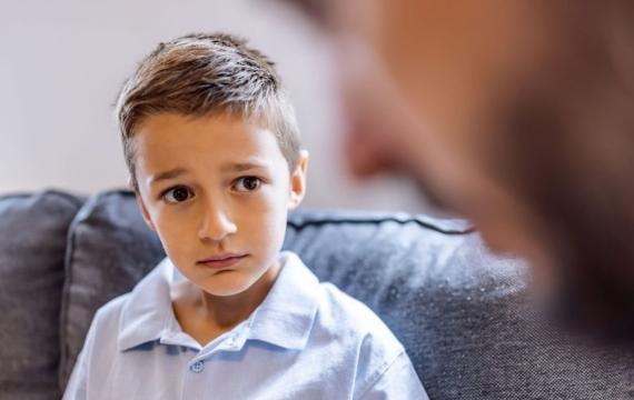 worried little boy talking to adult