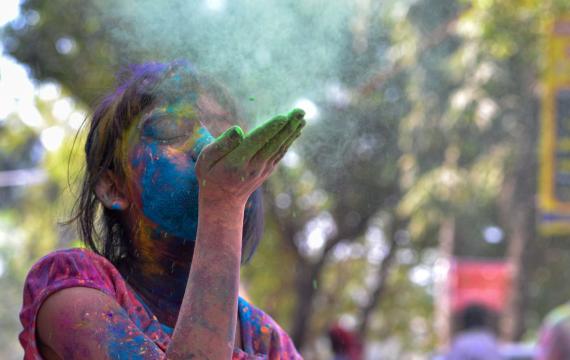 A-girl-blowing-colors-celebrating-holi-colors-best-seattle-area-Holi-events-kids-families-redmond-eastide