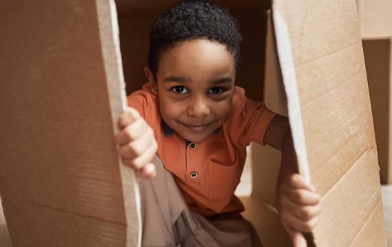 boy peeking out of a cardboard box
