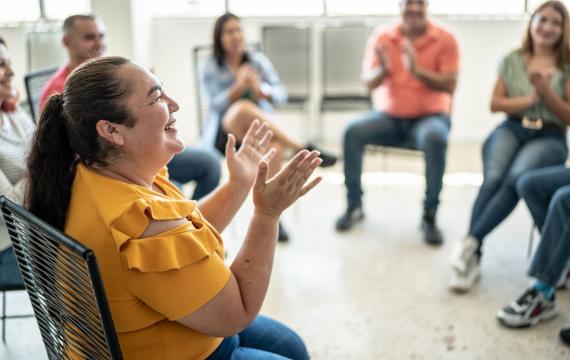 woman in a chair smiling and clapping
