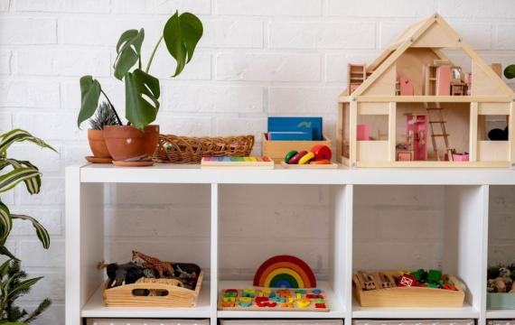 Montessori material white shelves in a room with neatly arranged toys