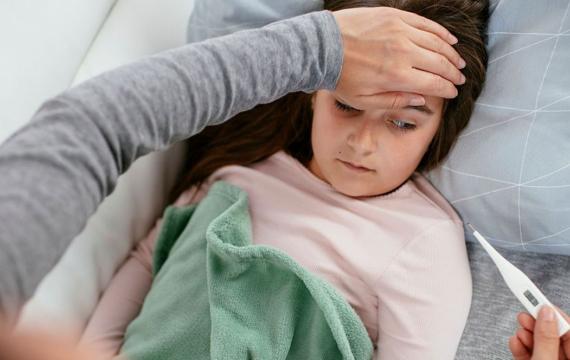 little girl sick checking body temperature with thermometer