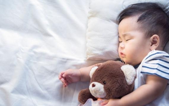 Newborn baby sleeping with teddy bear