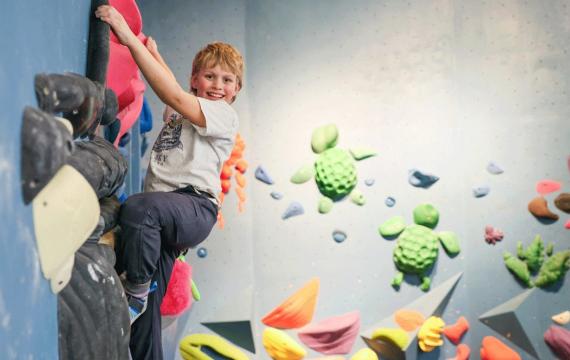 young boy climbing at an indoor rock climbing gym in Seattle