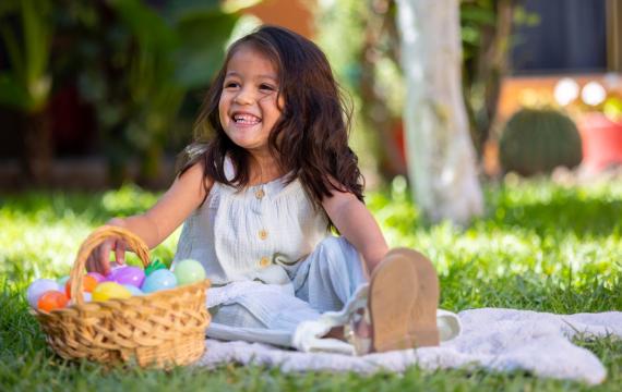 girl sitting with an Easter basket in the grass