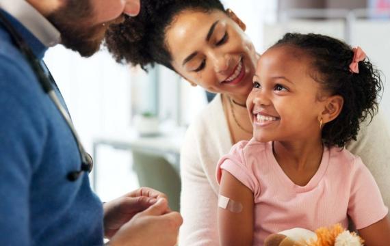 little girl at a primary health checkup with mother and doctor