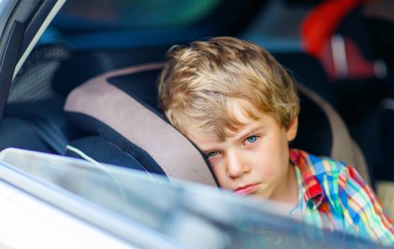 little boy feeling sick in car seat