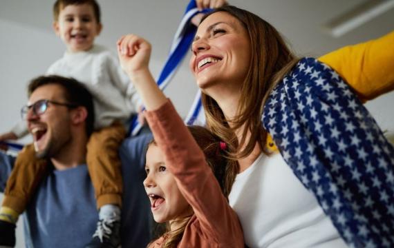family cheering while watching game at home