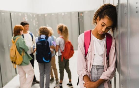 student leaning against locker, looking sad, worried about end of the school year