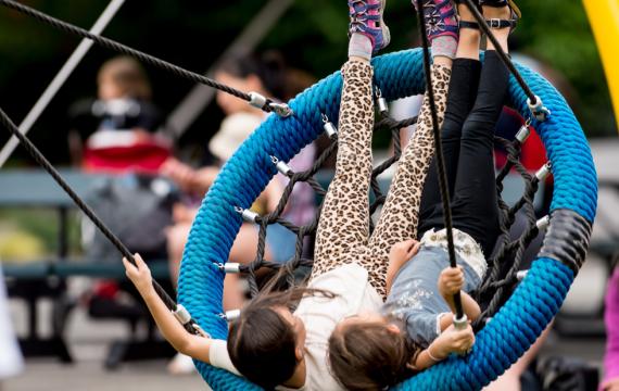 kids swinging on the Artists at Play Playground in Seattle Center, a fun weekend activity for Seattle families