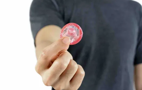 Teenage boy holding condom