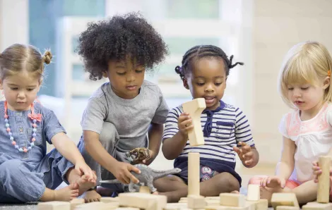 Four preschool kids play with blocks