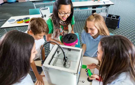 Kids around a 3-D printer