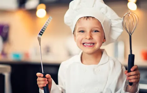 Boy in chef's hat and in kitchen