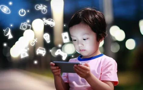 Child playing on phone outside