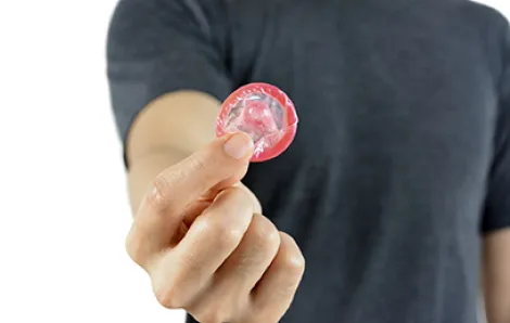 Teenage boy holding condom