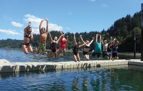 Summer campers jumping into water