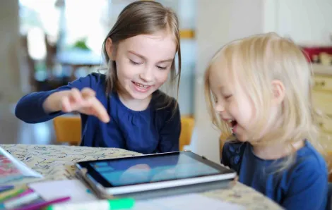 Two little girls playing on a tablet