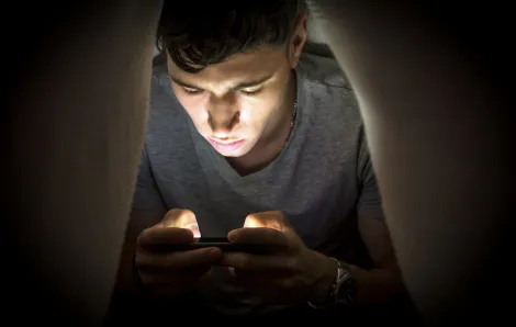 Night owl teen on his phone