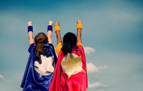 Two girls with superhero capes on