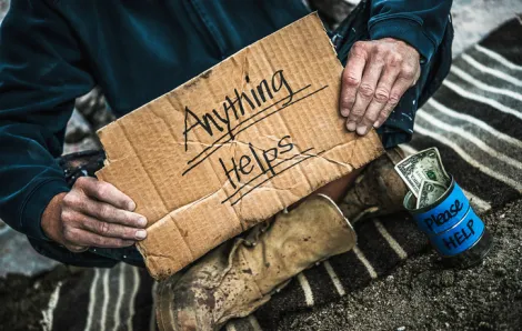 Homeless man with cardboard sign