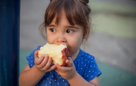 Little girl eating apple