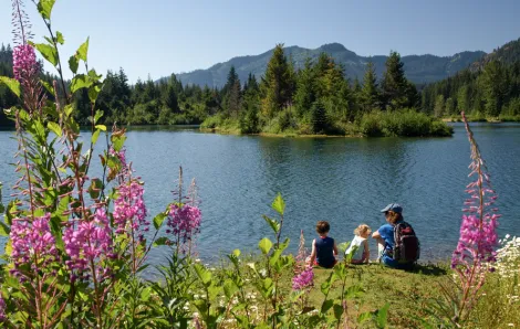 View of hikers resting Gold Creek pond, a hike for Seattle area families with toddlers and babies and strollers